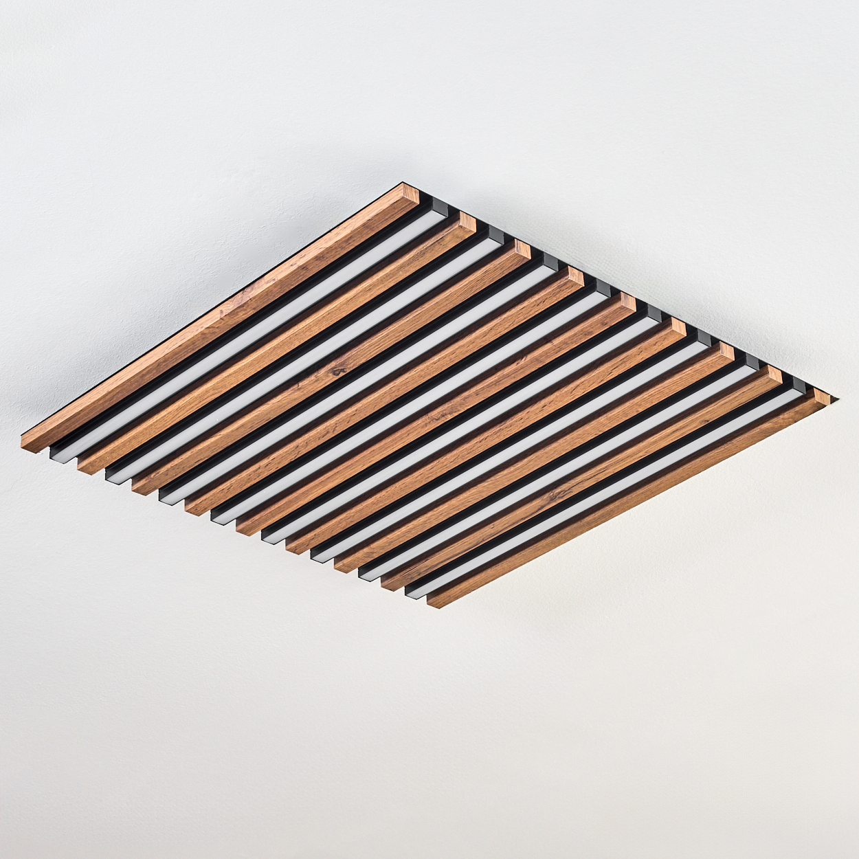 Holzdeckenpaneel mit abwechselnd braunen und weißen Streifen, schwarz gerahmt, vor weißer Decke.