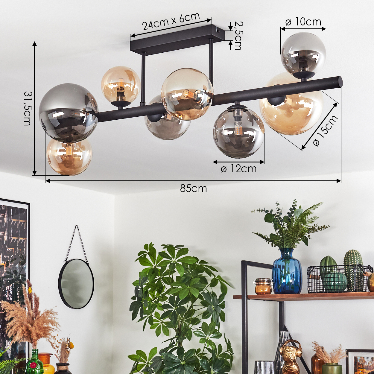 Eine moderne schwarze Deckenlampe mit mehreren Glaskugeln. Darunter ein Raum mit Pflanzen, einem Spiegel und einem Regal mit Dekoration.