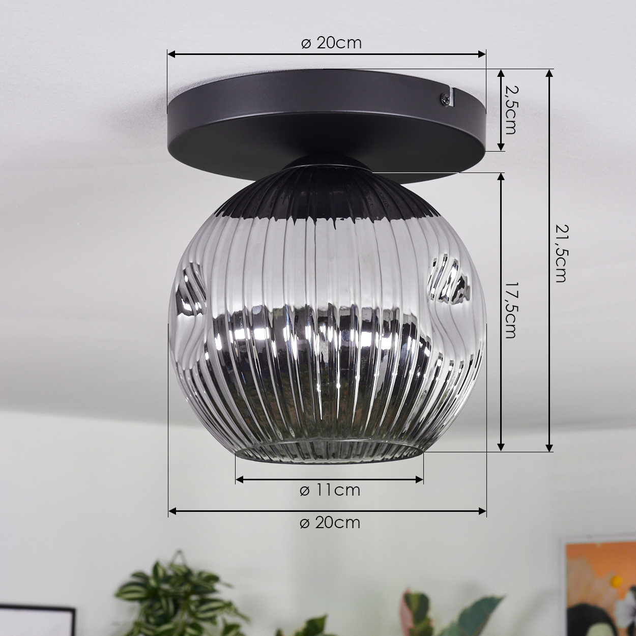 Eine moderne Deckenlampe mit schwarzem Sockel und rundem, silberfarbenem, geripptem Glasschirm. Abmessungen sind angegeben.