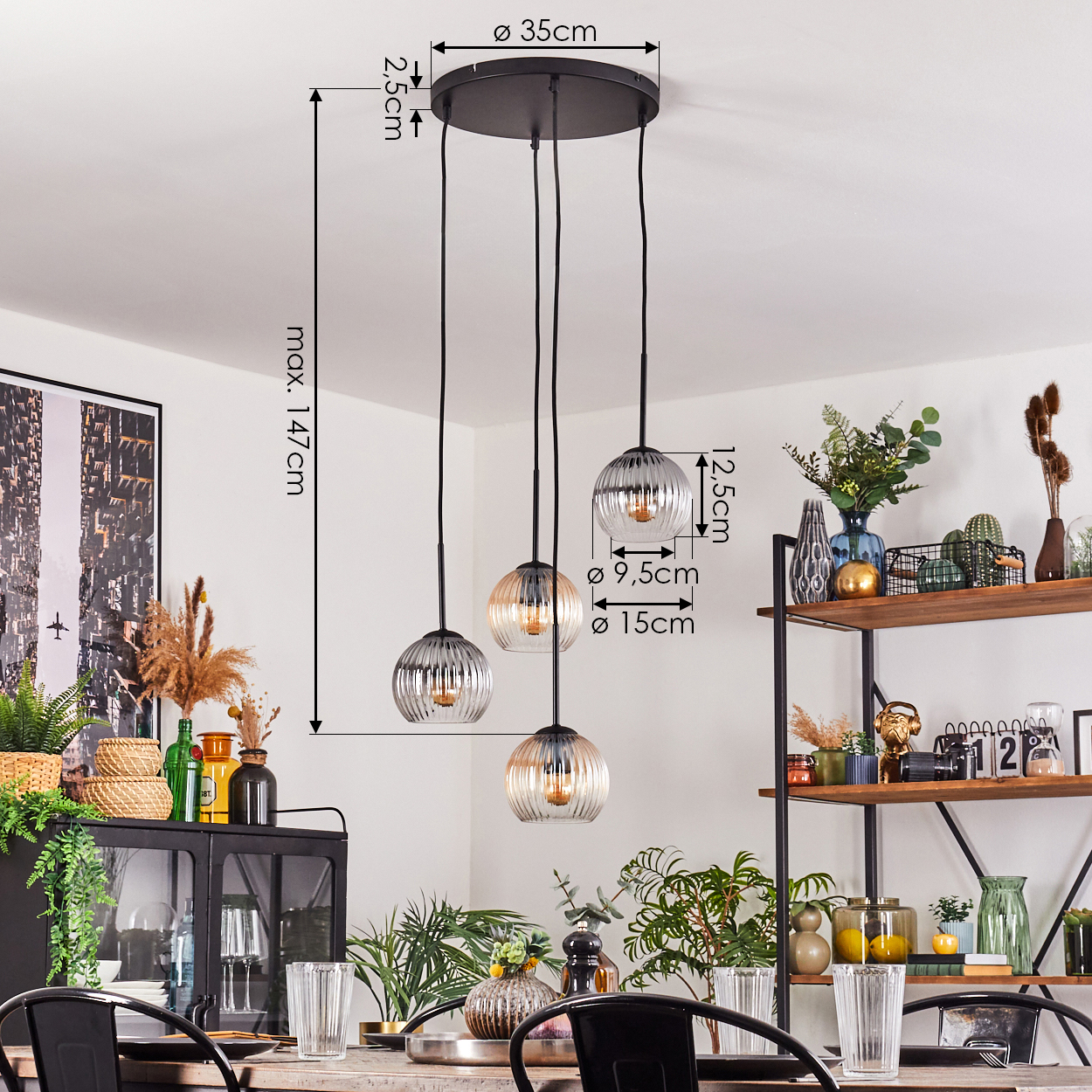Ein Esszimmer mit einem schwarzen Kronleuchter mit drei Glaskugel-Lampen. Regale mit Vasen und Pflanzen sind im Hintergrund.