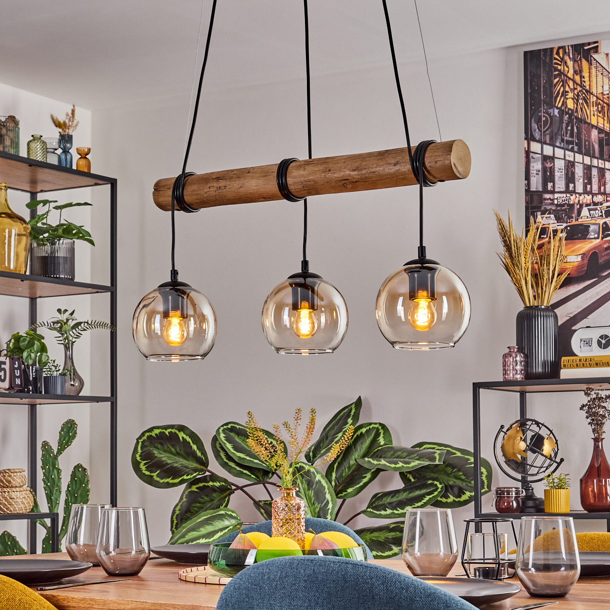 Esszimmer mit Holzbalken-Leuchte, Tisch, Pflanzen, Gläsern und einem Gemälde eines gelben Taxis.