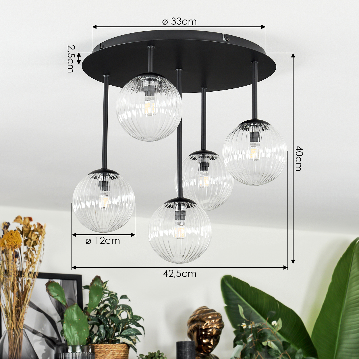 Eine moderne Deckenlampe mit fünf Glaskugeln, schwarzen Stielen und einem schwarzen kreisförmigen Sockel. Abmessungen angegeben.