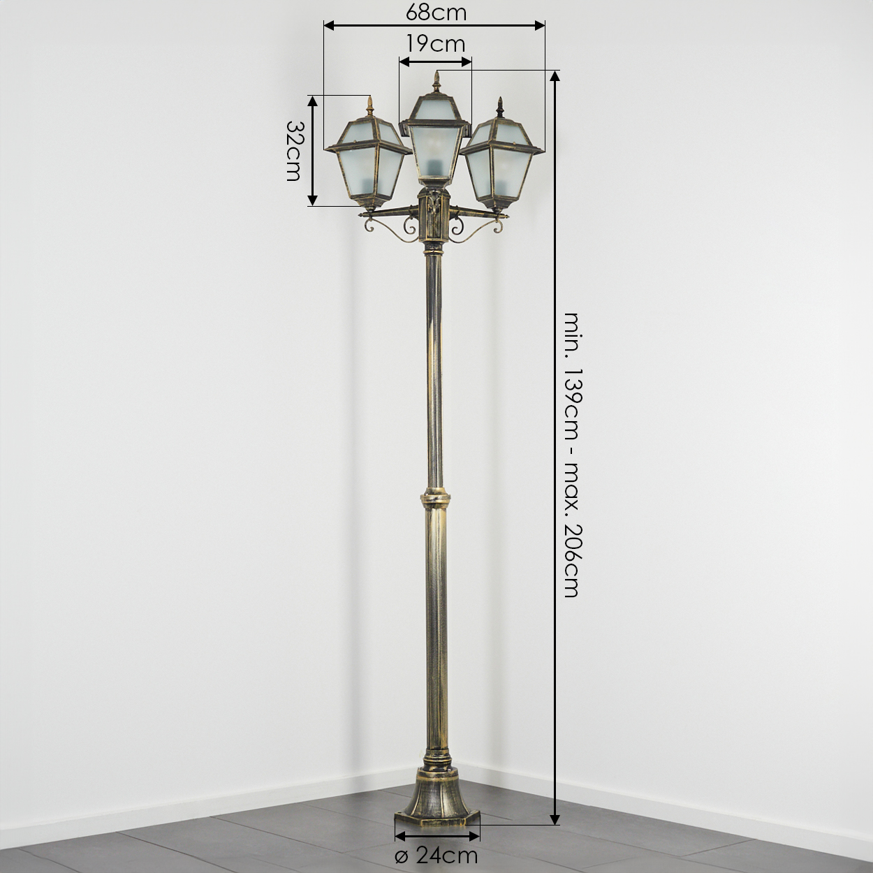 Eine goldene Straßenlaterne mit drei Laternen. Abmessungen sind angegeben. Die Lampe steht auf einem dunklen Boden vor einer weißen Wand.