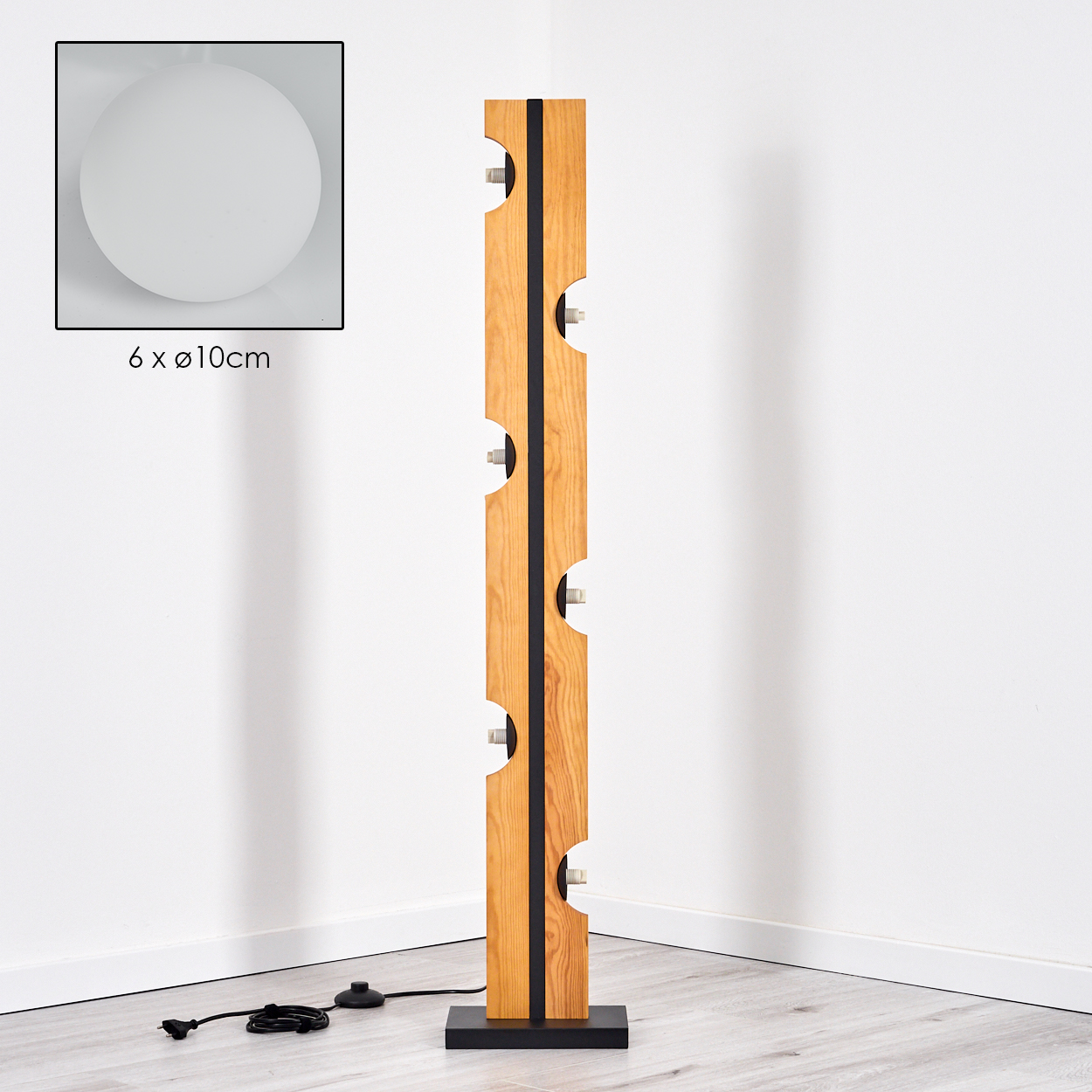 Eine Holz-Stehlampe mit sechs Lichtern. Sie hat einen schwarzen Sockel und einen schwarzen Streifen in der Mitte. Eine weiße Kugel in der Ecke.