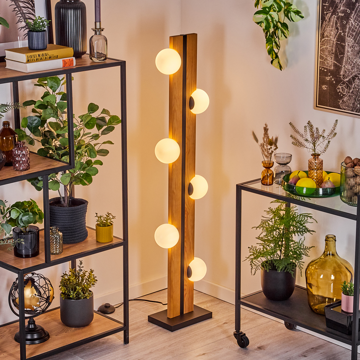 Ein modernes Wohnzimmer mit Holzlampe, Regalen mit Pflanzen und einem Beistelltisch mit Dekoration und Obst.