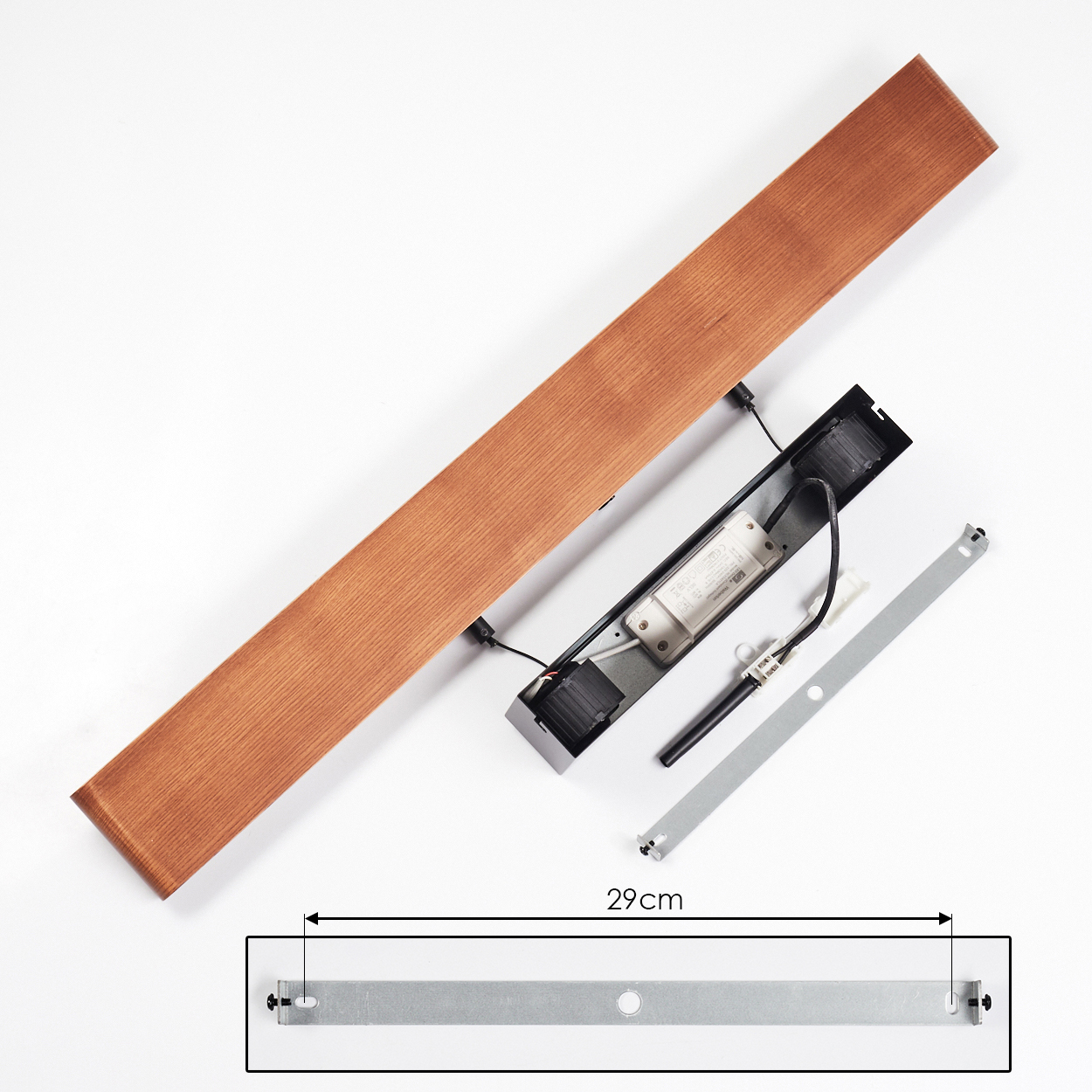 Zerlegte Holzleuchte mit Metallkomponenten. Enthält ein 29cm Maß. Teile auf weißer Oberfläche ausgebreitet.