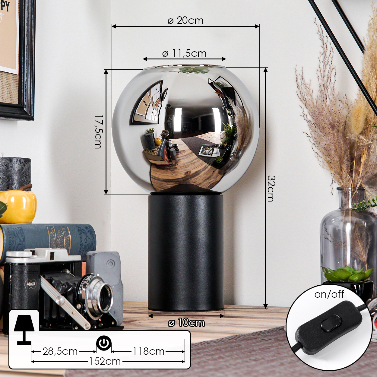 Eine moderne Lampe mit reflektierendem Globus und schwarzem Sockel. Abmessungen sind beschriftet. Eine Vintage-Kamera und Dekoration sind im Hintergrund.