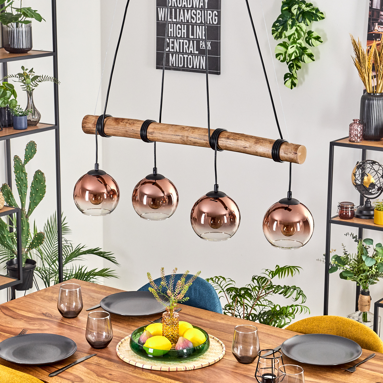 Esszimmer-Setup mit Holztisch, kupferfarbenen Pendelleuchten und Tischgedeck. Pflanzen und Dekorationsartikel tragen zum Ambiente bei.