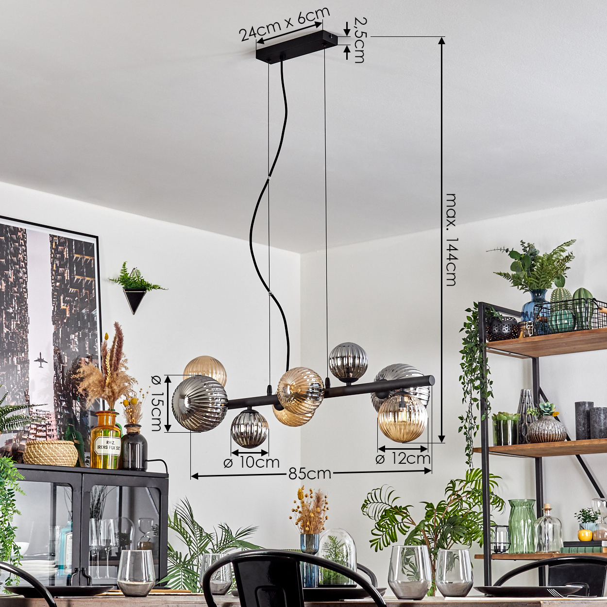 Eine moderne Hängelampe mit Glaskugeln hängt über einem Tisch. Im Hintergrund ein Regal mit Deko und ein Schrank.
