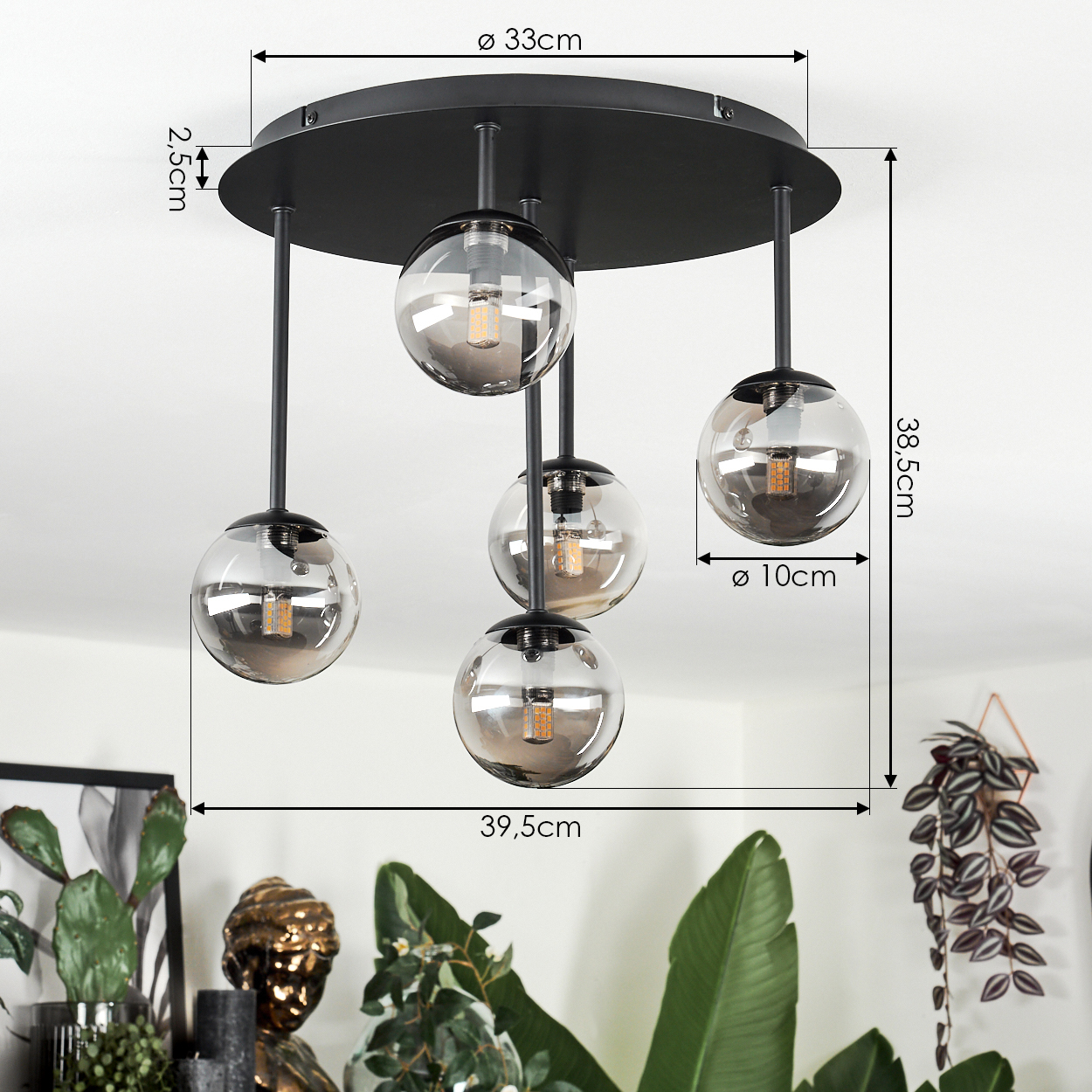 Moderne schwarze Deckenlampe mit fünf Glaskugel-Schirmen, Maße angegeben. Pflanzen und eine Büste im Vordergrund.