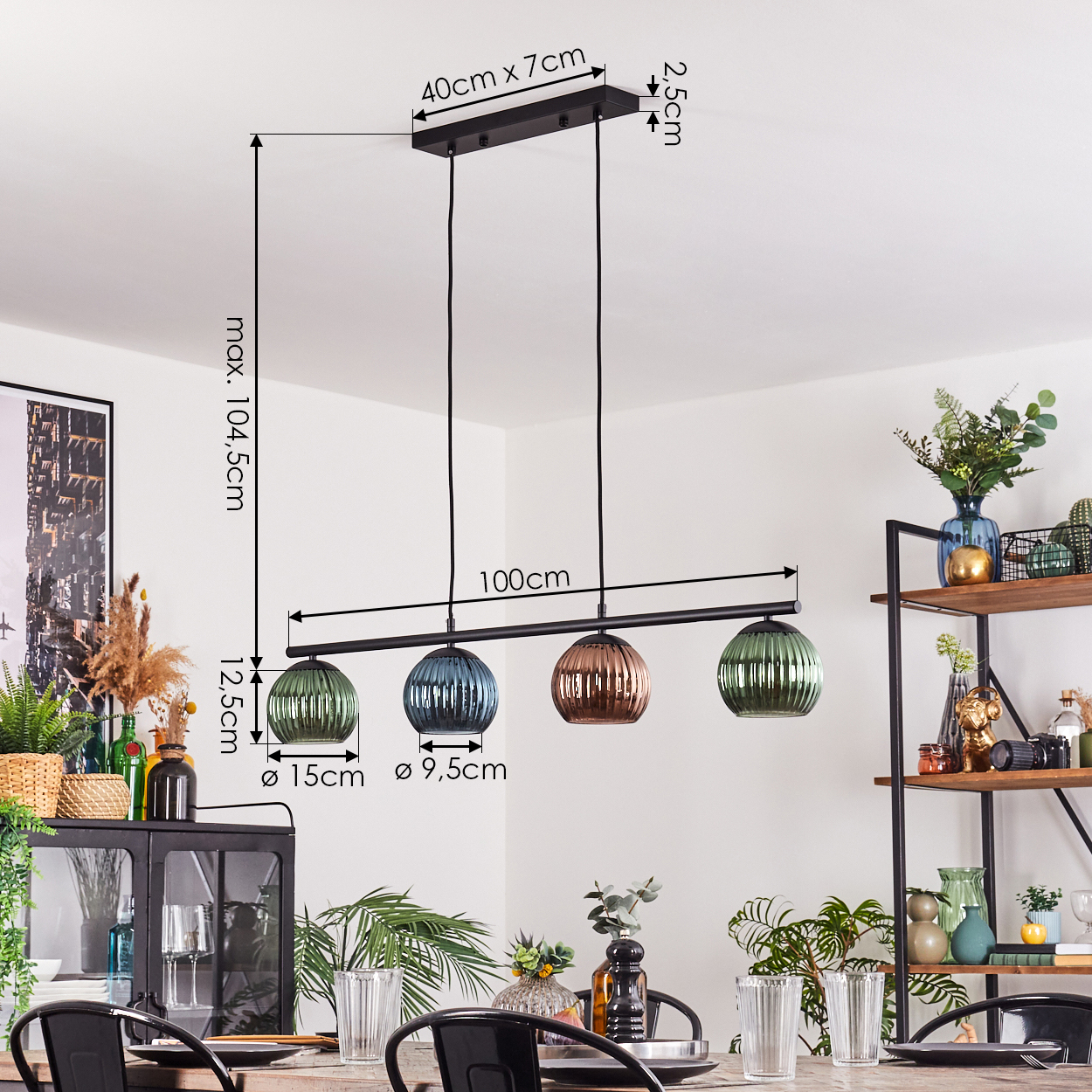 Ein modernes Esszimmer mit einem schwarzen Kronleuchter mit vier Glas-Pendelleuchten. Es gibt Pflanzen, einen Tisch und ein Regal.