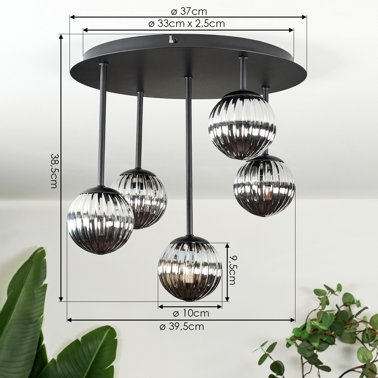 Eine moderne Deckenlampe mit fünf kugelförmigen, gerippten Glasschirmen. Die Lampe hat einen schwarzen Sockel und Aufhängestangen.