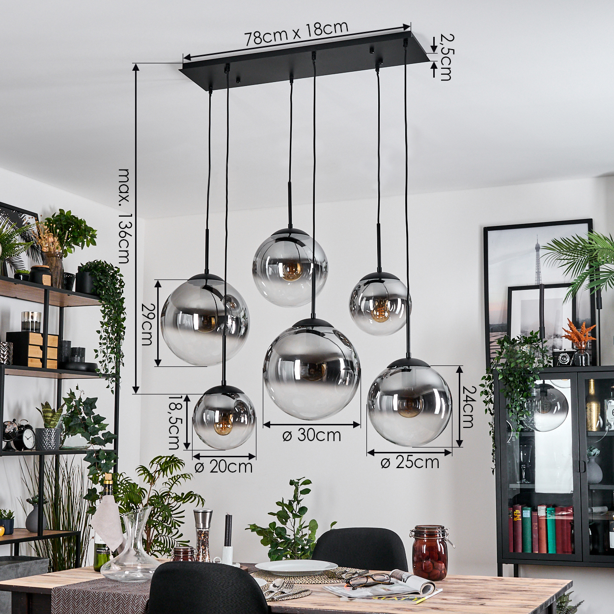 Ein Esszimmer mit Holztisch, Stühlen und einer Hängeleuchte mit Glaskugelschirmen. Pflanzen und Dekoration sind ebenfalls vorhanden.