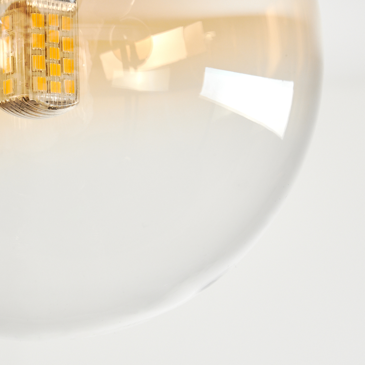 Nahaufnahme einer Glühbirne. Ein Teil der Glühbirne ist sichtbar, mit transparentem Glas und einem Teil mit kleinen gelben Lichtern.