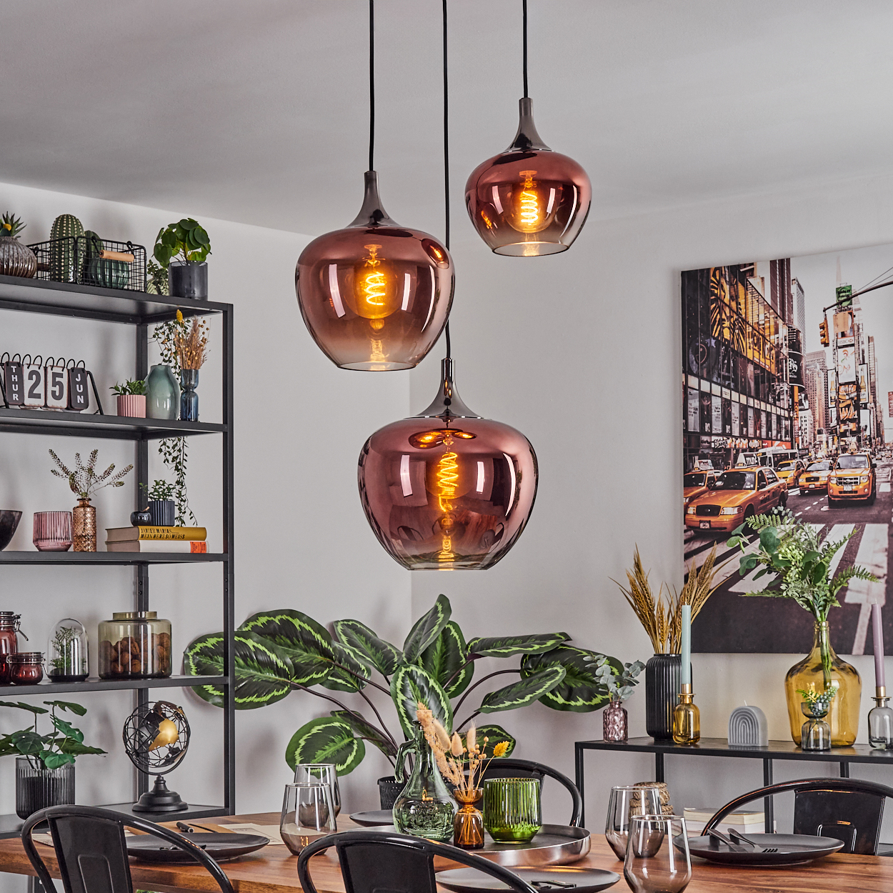 Esszimmer mit drei Hängelampen. Tisch mit Gläsern und Tellern gedeckt. Regale mit Pflanzen und Dekoration. Ein Stadtgemälde.