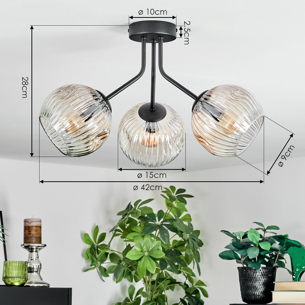 Eine moderne Deckenlampe mit drei Glasschirmen. Der Raum hat Pflanzen und Dekorationsartikel auf einer dunklen Oberfläche.