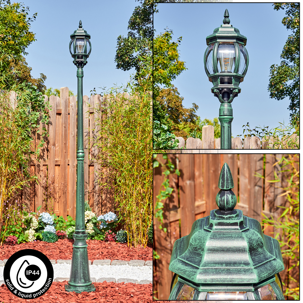 Eine grüne Außenlaterne steht in einem Garten. Bambus, Blumen und ein Holzzaun sind im Hintergrund. Die Lampe ist verziert.