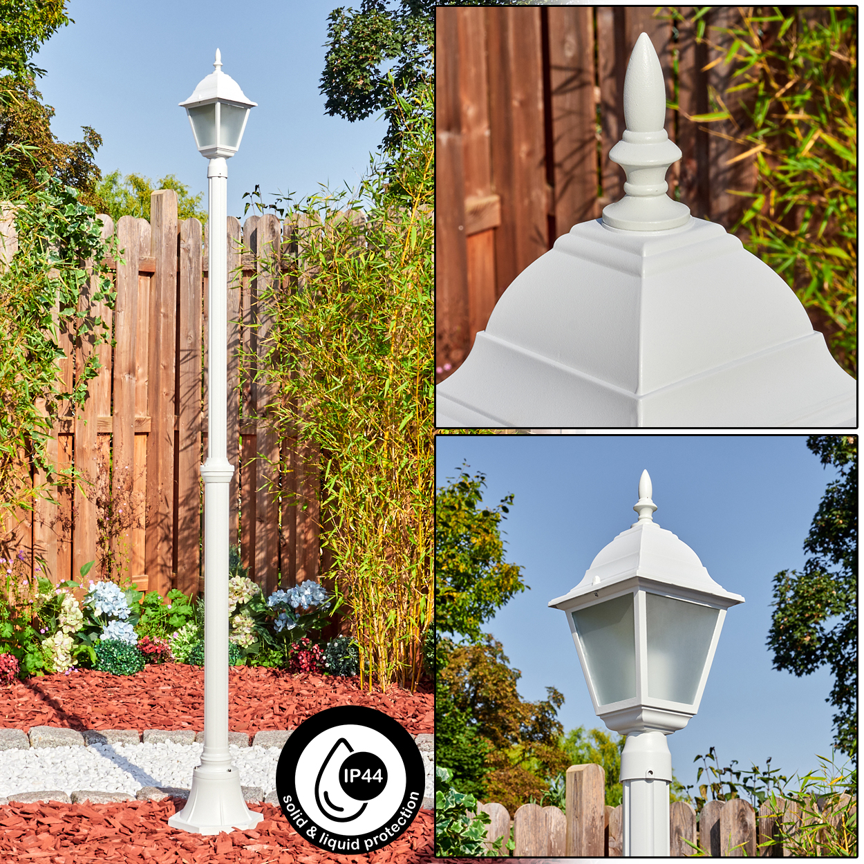 Eine weiße Außenlaterne in einem Garten. Die Lampe befindet sich in der Nähe eines Holzzauns und ist von Pflanzen umgeben.
