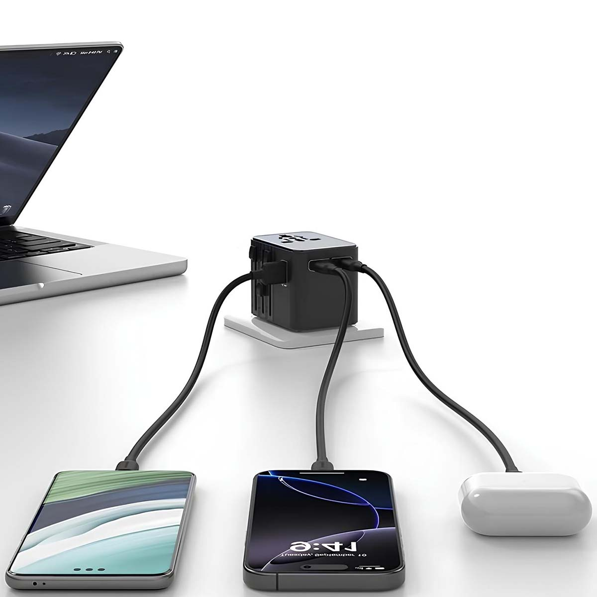Un ordinateur portable, un hub de charge noir avec des câbles connectés à des téléphones et un étui d'écouteurs blanc.