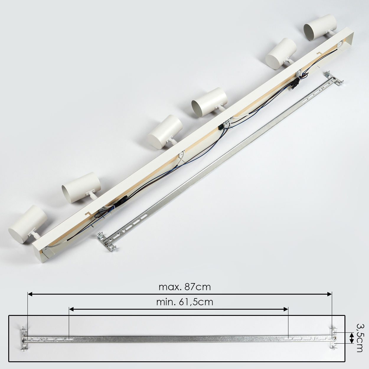 Ein weißer Deckenstrahler mit sechs Lampen. Darunter eine Metallstange mit Abmessungen. Max. 87 cm, min. 61,5 cm und 3,5 cm Höhe.