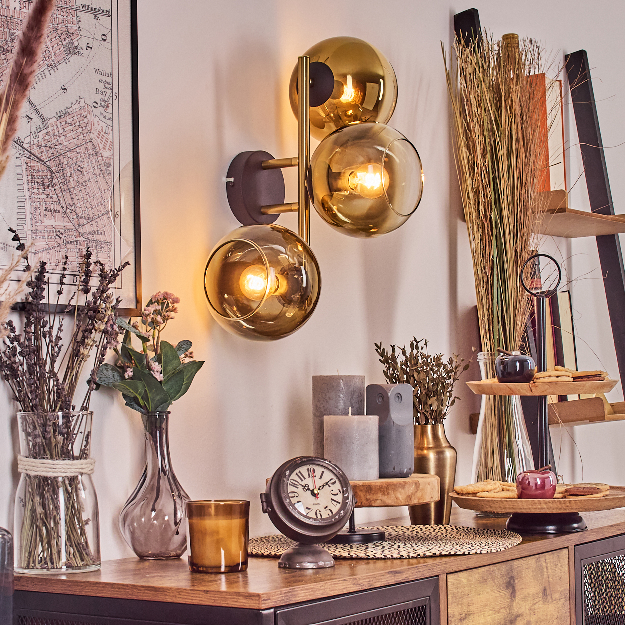 Ein Raum mit Wandlampe, Uhr, Blumen, Kerzen und Karte. Holzmöbel und Dekoration mit gemütlicher, warmer Atmosphäre.