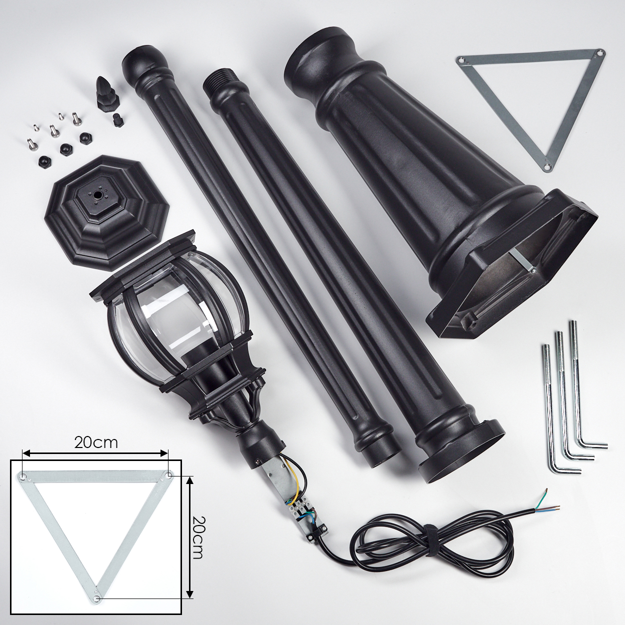 Zerlegte schwarze Laternenpfahlteile auf weißer Oberfläche. Komponenten umfassen Lampe, Stangen, Sockel, Schrauben und ein dreieckiges Metallstück.