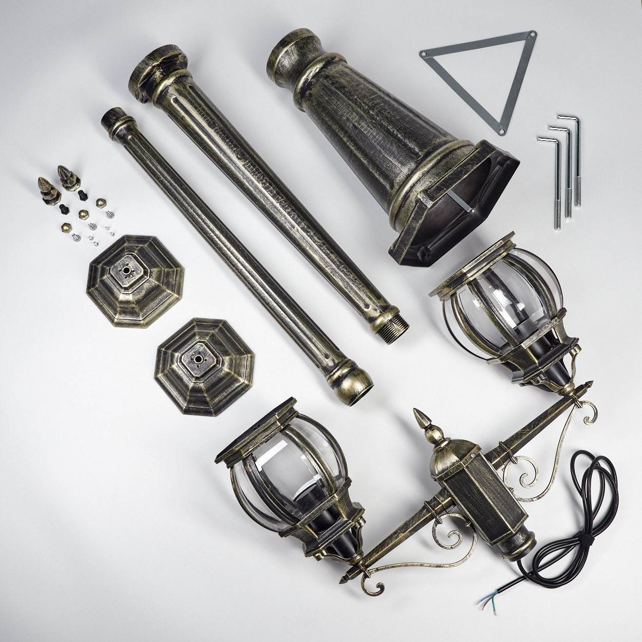 Zerlegte Teile einer Außenlampe auf weißem Hintergrund. Enthält Stangen, Lampenköpfe, Schrauben und ein dreieckiges Metallteil.