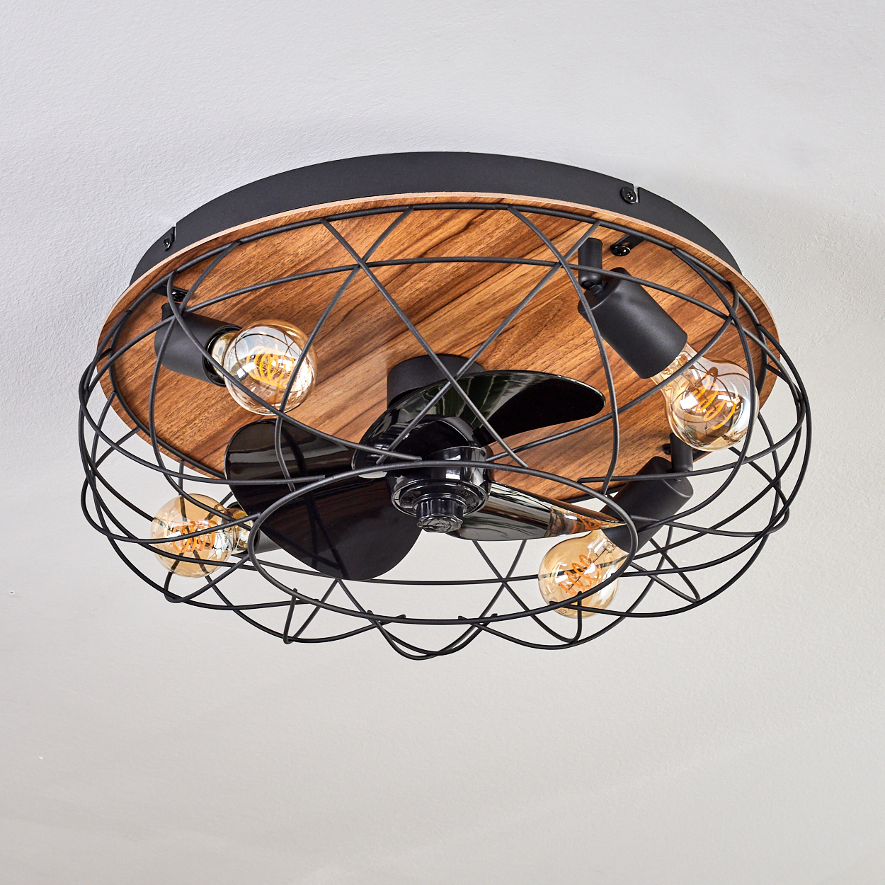 Deckenventilator mit Holzsockel, vier Glühbirnen, schwarzen Flügeln und Metallkäfig.