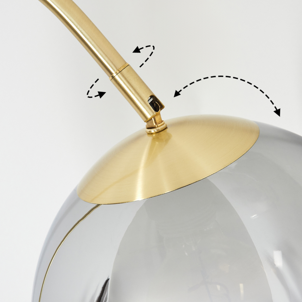 Nahaufnahme einer modernen Lampe. Sie hat einen goldfarbenen Arm und einen kugelförmigen, rauchgrauen Glasschirm. Pfeile zeigen mögliche Bewegungen an.