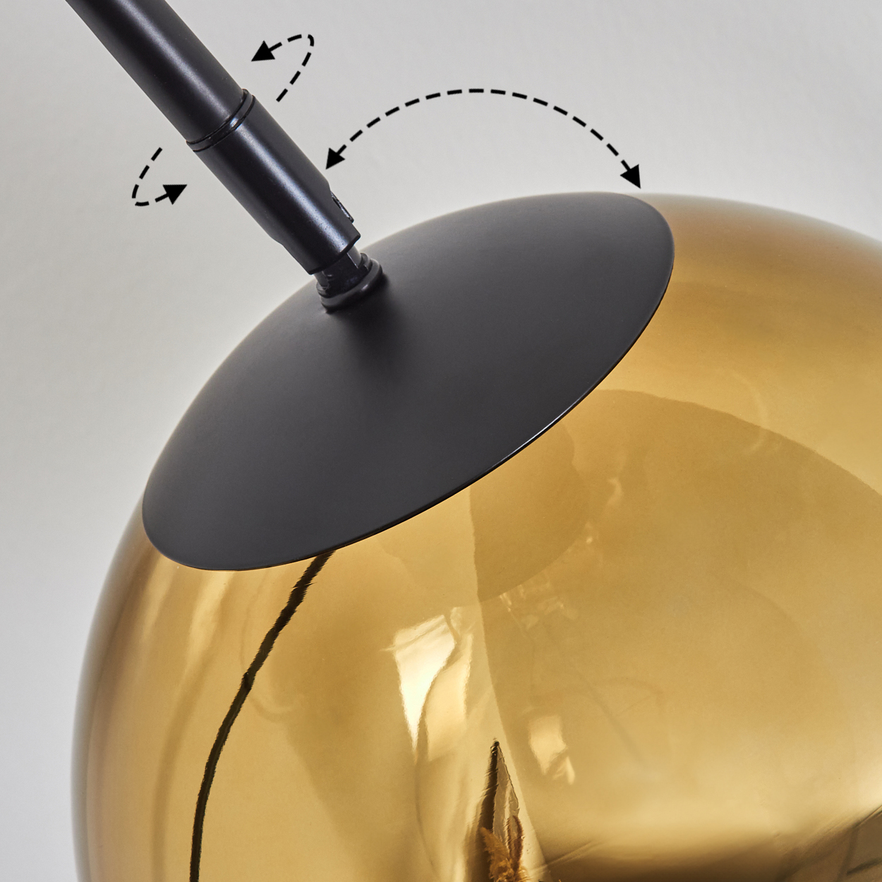 Nahaufnahme einer modernen Lampe. Sie hat einen goldenen Globus und einen schwarzen Metallrahmen. Pfeile zeigen die Einstellung an.