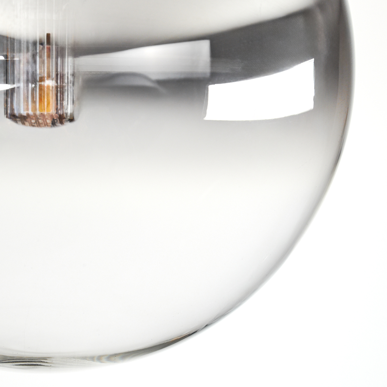 Nahaufnahme einer Glaskörper-Leuchte. Die transparente Glühbirne ist teilweise sichtbar und reflektiert Licht. Der Innenmechanismus ist ebenfalls zu sehen.