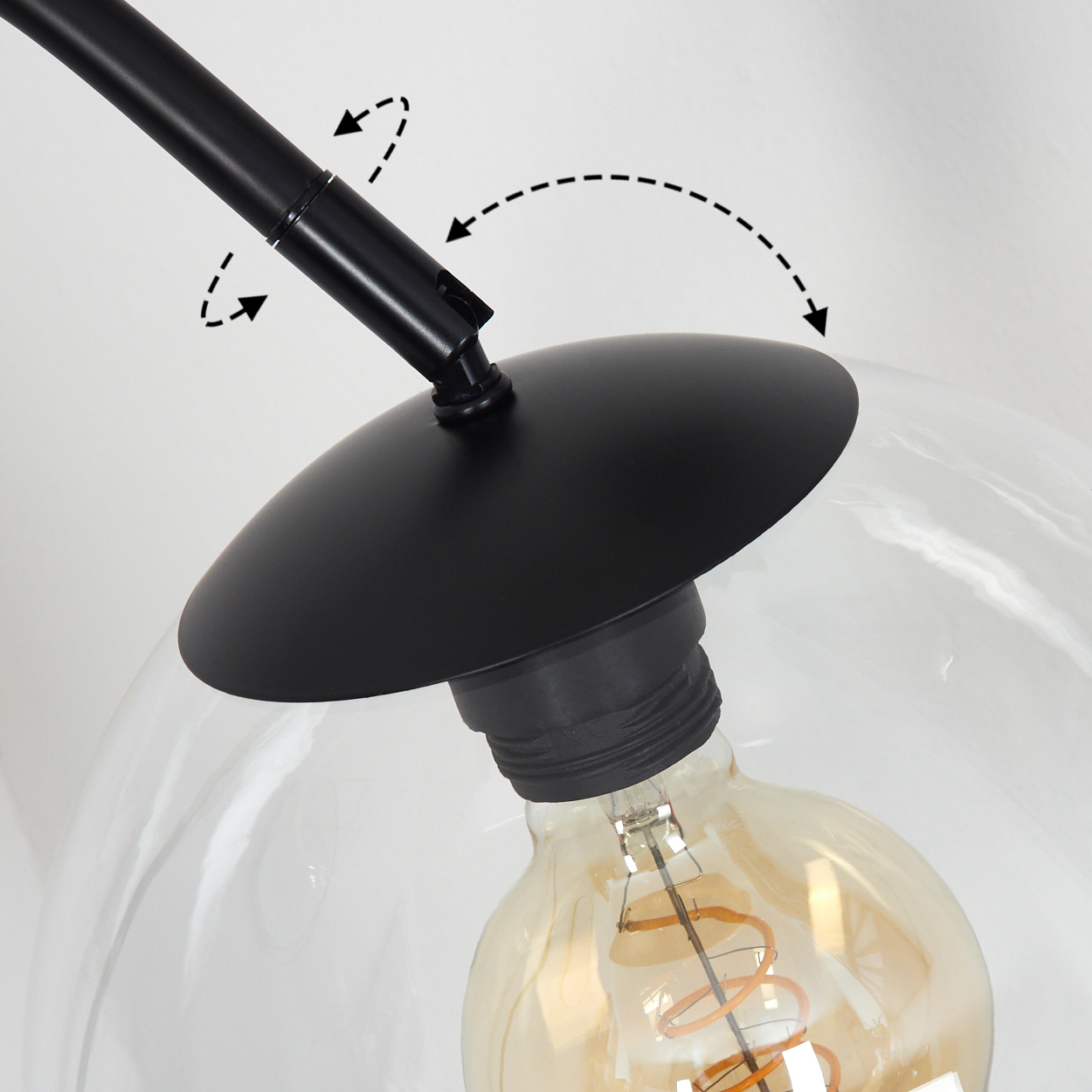 Nahaufnahme einer schwarzen Lampe mit klarem Glasschirm und sichtbarer Glühbirne. Pfeile zeigen die Bewegung an.