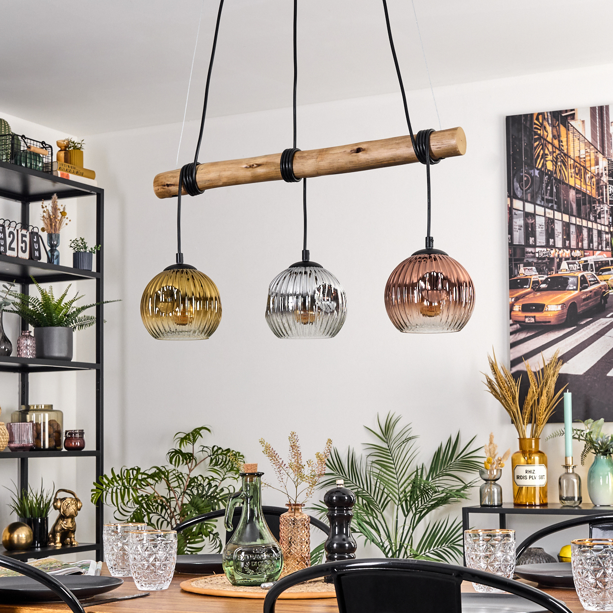 Esszimmer mit Holztisch, drei Pendelleuchten und einem Kunstwerk einer New Yorker Straße.