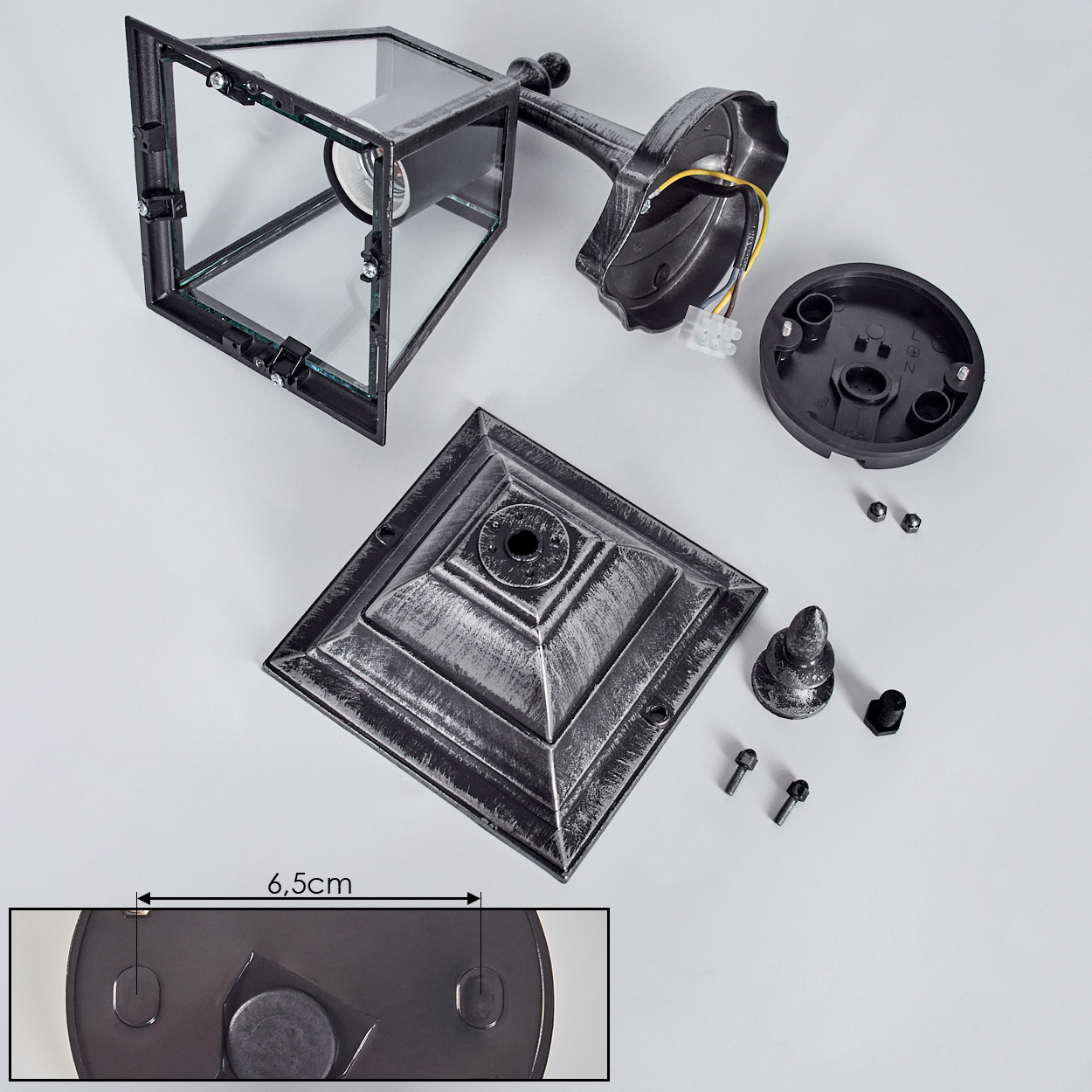 Zerlegte Außenlampe mit Glaspaneelen, Metallrahmen und Sockel. Verschiedene Teile, darunter Schrauben und Kabel, sind sichtbar.