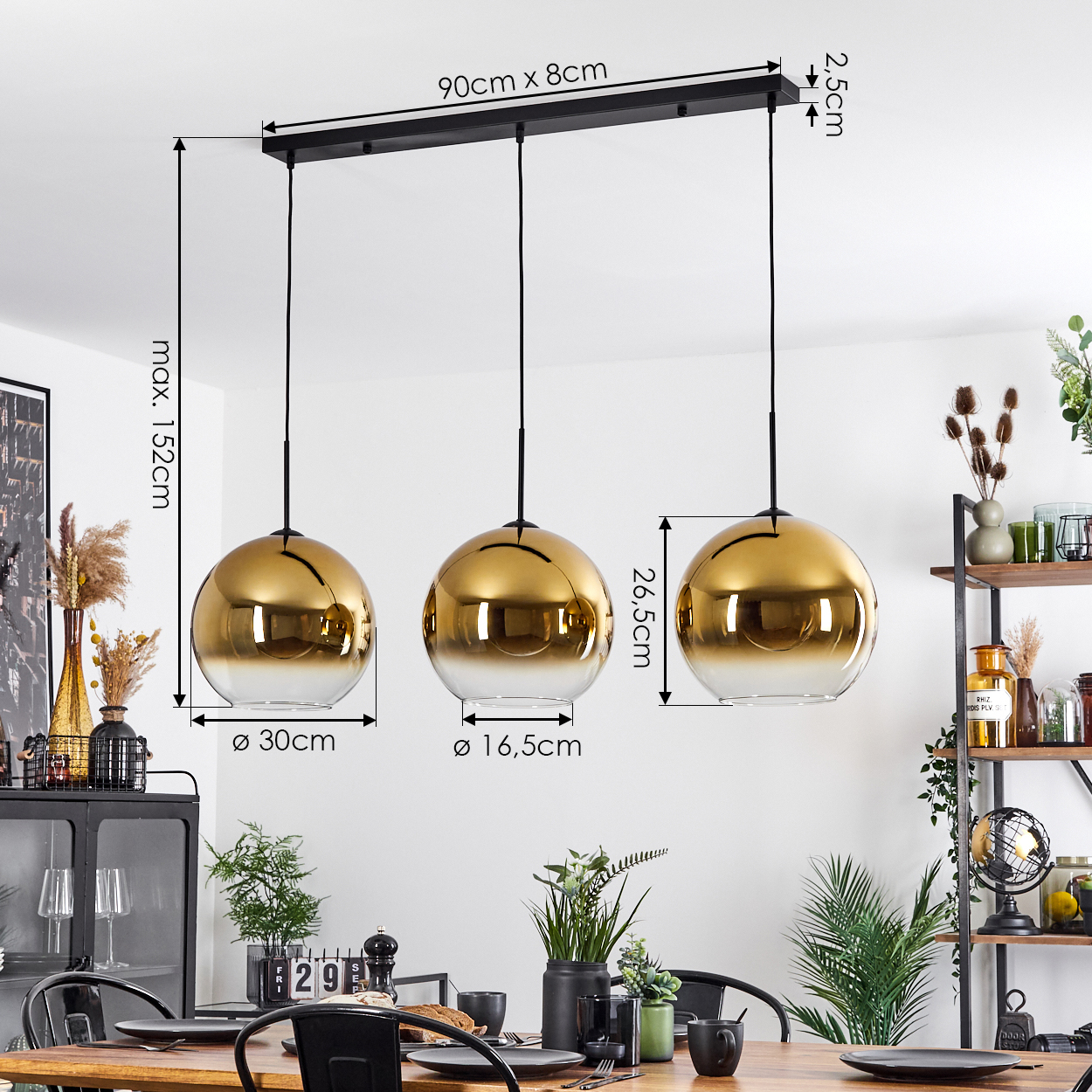 Drei gold- und gläserne Pendelleuchten hängen über einem Esstisch, der für eine Mahlzeit gedeckt ist. Die Abmessungen sind angegeben.