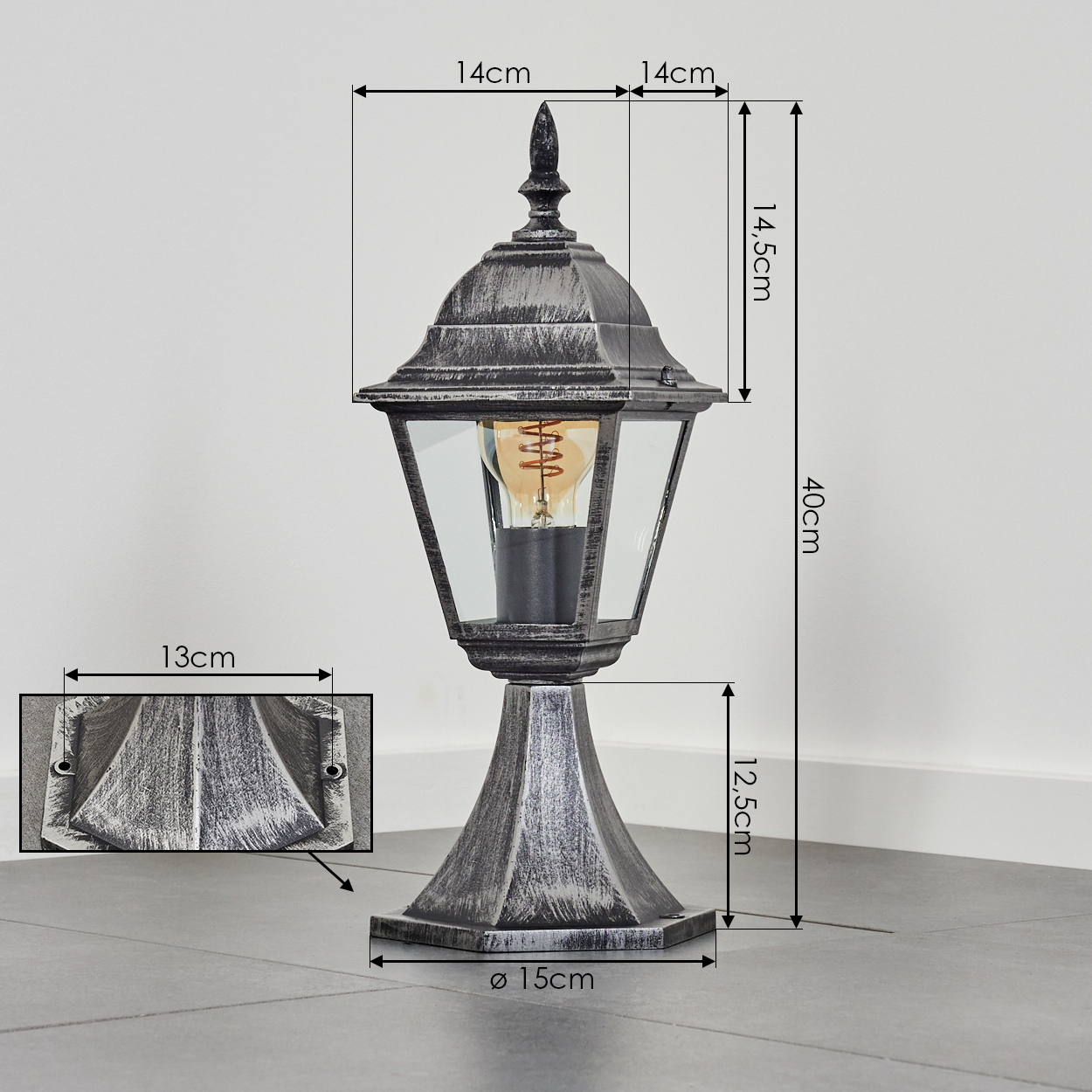 Eine dekorative Außenlampe. Sie hat eine schwarz-silberne Oberfläche. Die Lampe enthält Maße für Höhe und Breite sowie eine Nahaufnahme des Sockels.