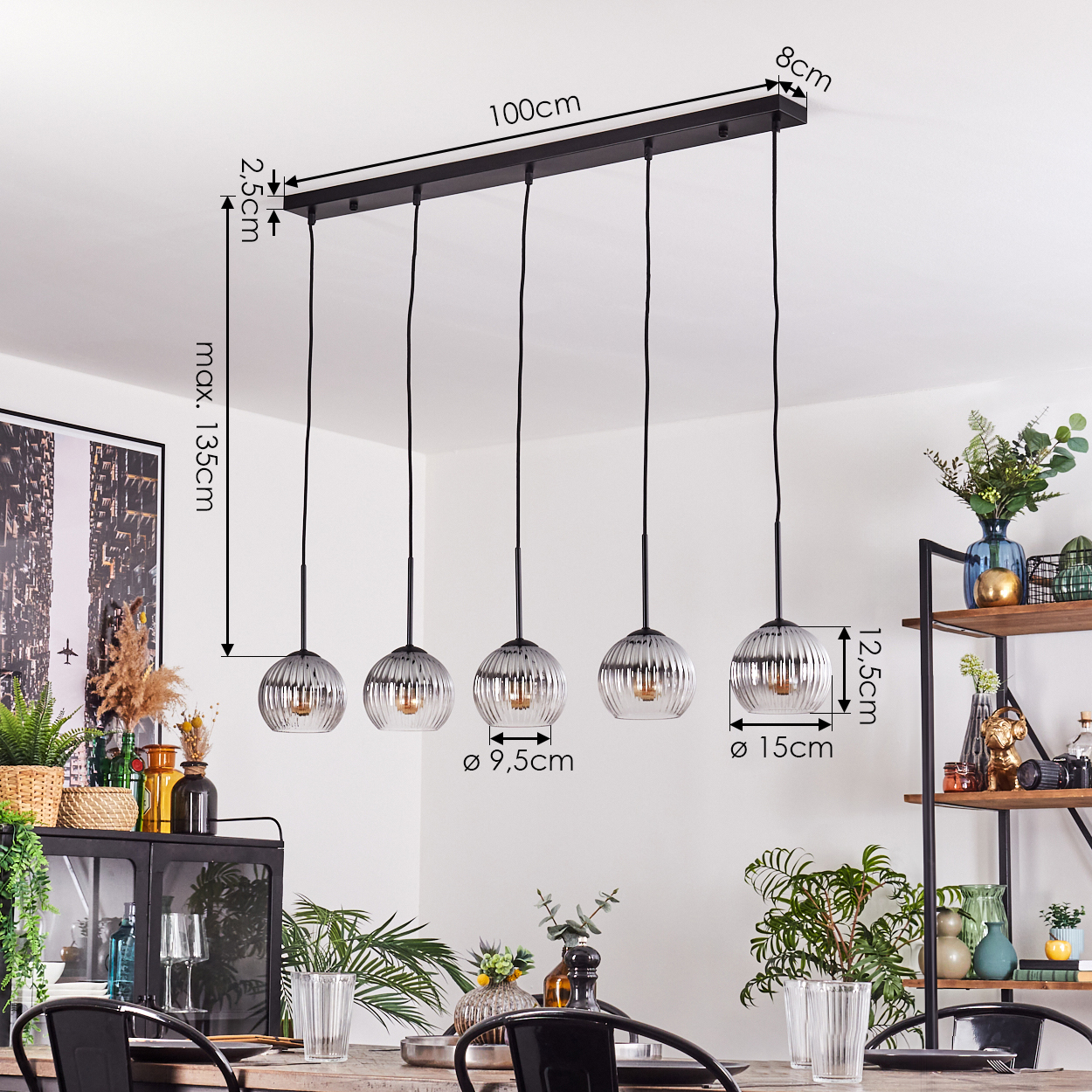 Ein Esszimmer mit Tisch, Stühlen und einer schwarzen Leuchte mit fünf Glaskugelleuchten. Maße sind angegeben.