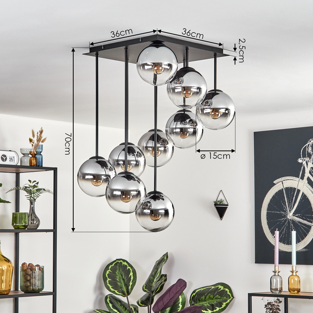 Eine moderne Deckenlampe mit neun kugelförmigen Chrom-Lampenschirmen. Abmessungen sind angegeben. Dekorative Gegenstände und Pflanzen sind ebenfalls sichtbar.