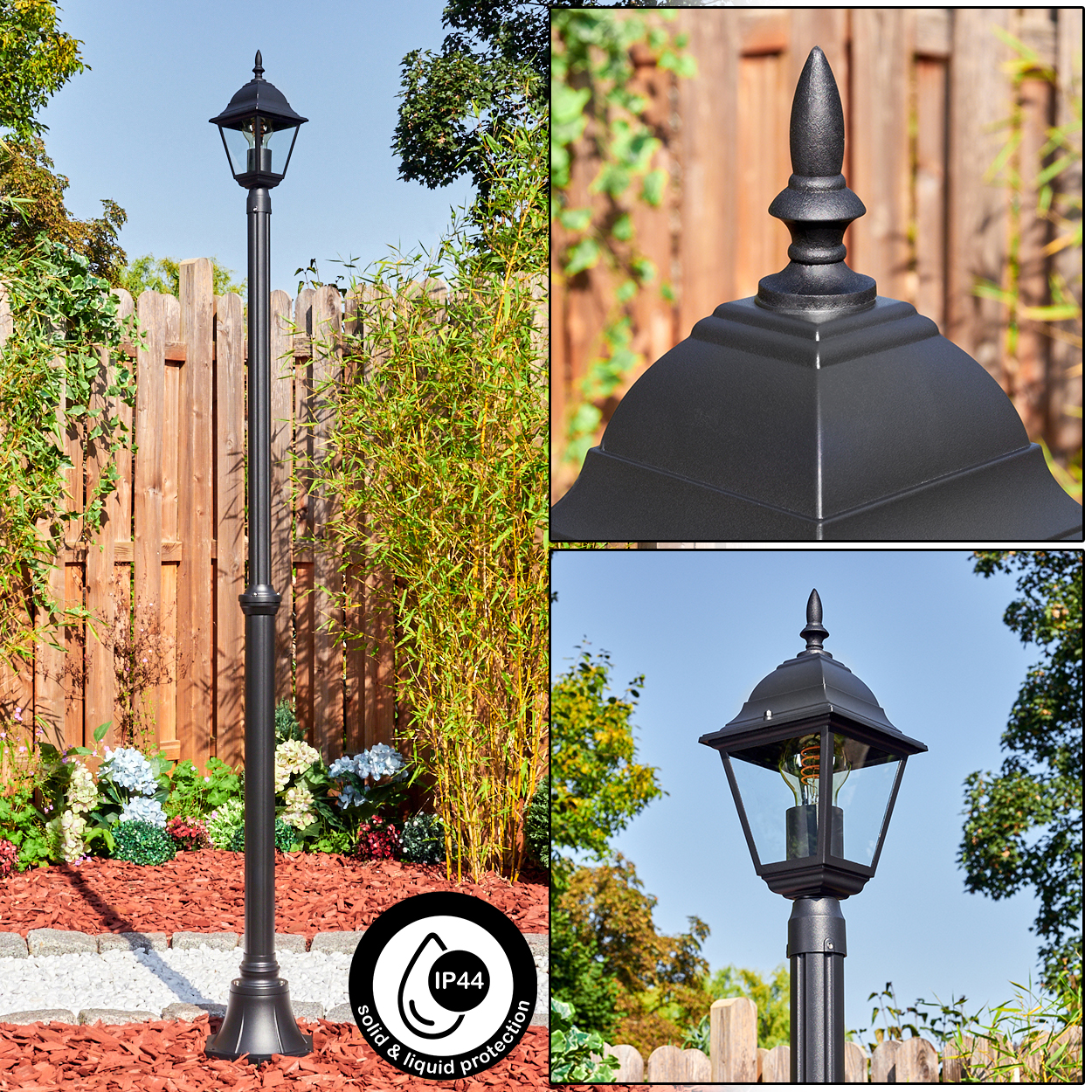 Schwarze Außenlaterne mit dekorativer Spitze, in einem Garten mit Pflanzen und Holzzaun aufgestellt.