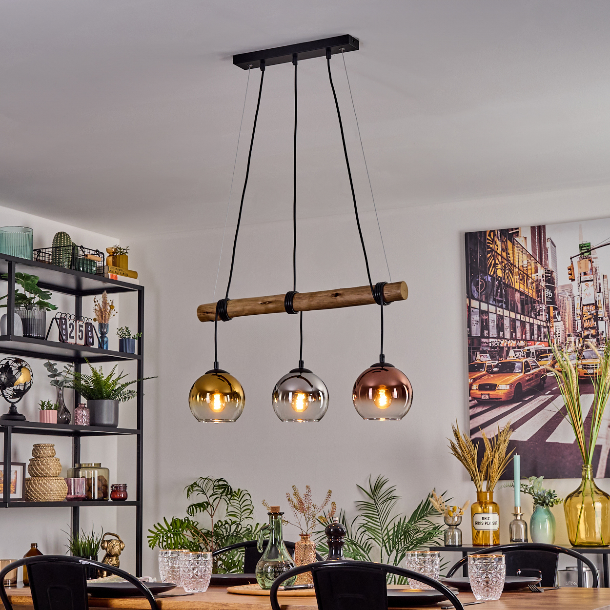 Esszimmer mit Holztisch, Kronleuchter mit drei Glaslampen und Stadtbildmalerei an der Wand.