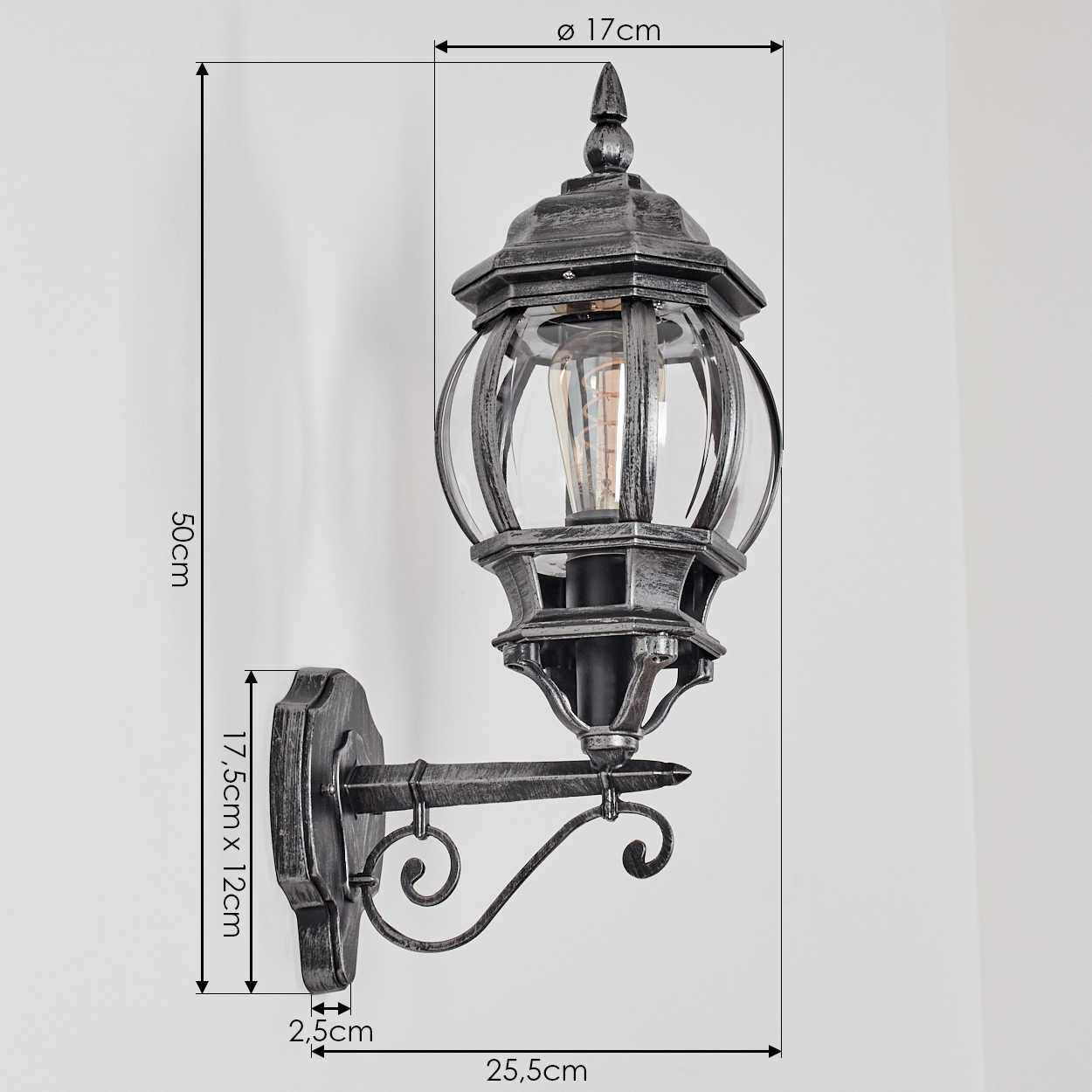 Eine dekorative Außenwandlampe mit angegebenen Abmessungen. Sie ist silber-schwarz und an einer weißen Wand befestigt.