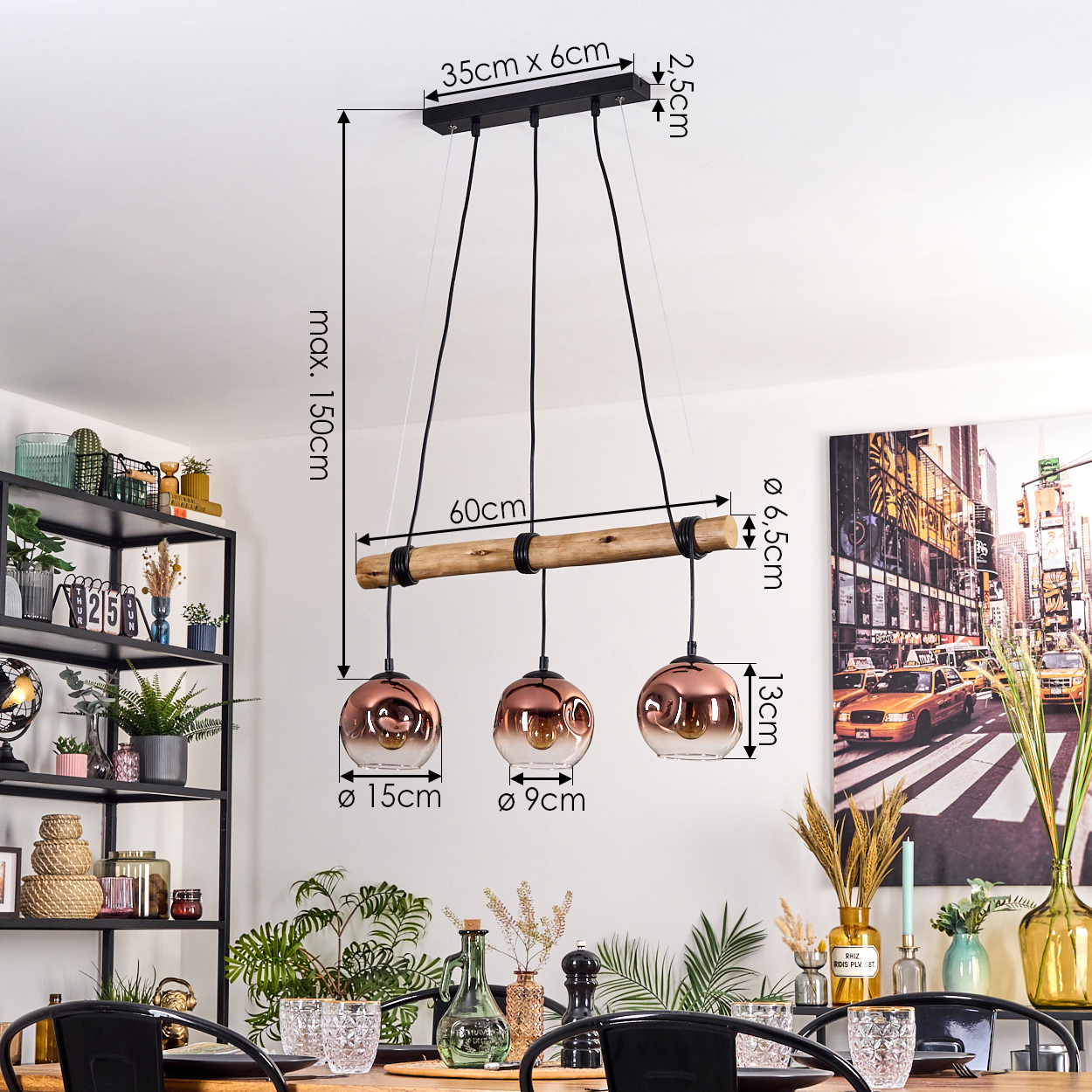 Eine moderne Hängelampe mit drei kupferfarbenen Glaskugeln hängt über einem Holztisch, der für ein Abendessen gedeckt ist. Im Hintergrund sind ein Regal und Kunstwerke zu sehen.