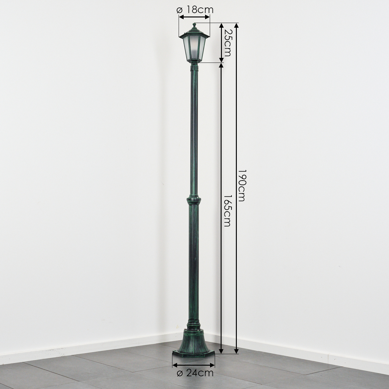 Eine grüne Straßenlaterne steht in einer Ecke. Maße angegeben: 190 cm hoch, 18 cm Lampenbreite, 24 cm Basisdurchmesser. Weißer Hintergrund.