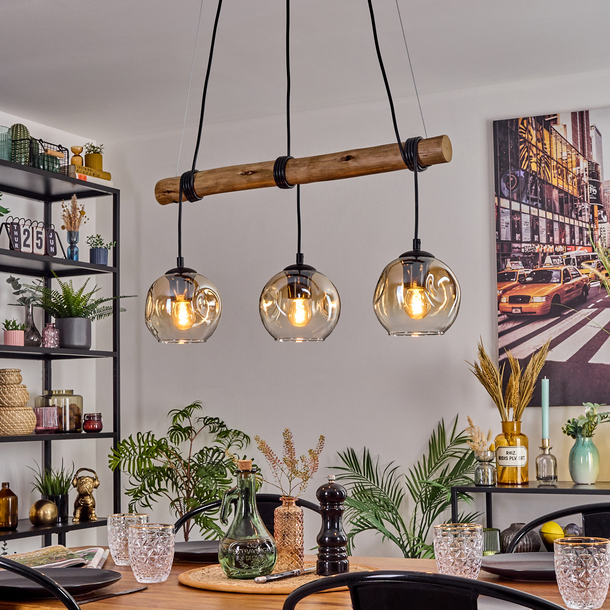 Esszimmer mit Holztisch, drei hängenden Kugelleuchten, Pflanzen und einem New York City Foto.