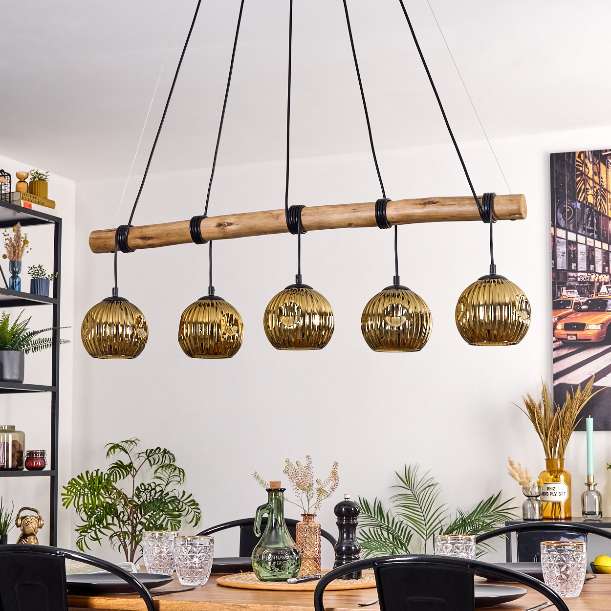 Esszimmer mit Holztisch, schwarzen Stühlen und einer Leuchte mit fünf goldenen Kugellichtern.