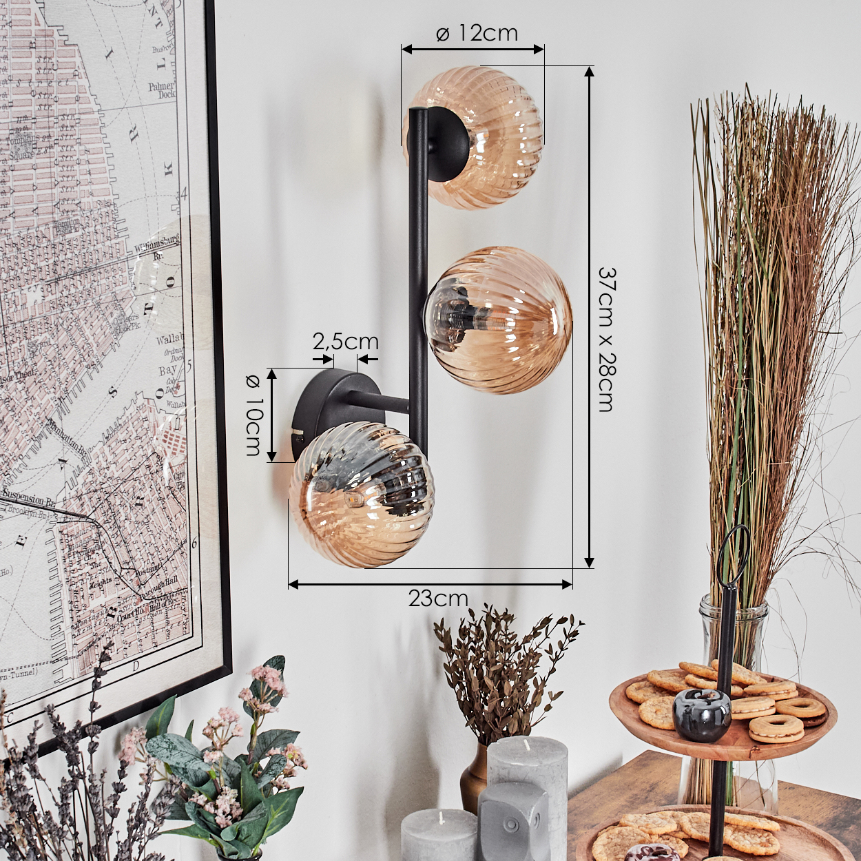 Eine Wandlampe mit drei Glaskugeln, eine Karte und Dekorationsartikel. Die Lampe hat Abmessungen und Messungen, die im Bild beschriftet sind.
