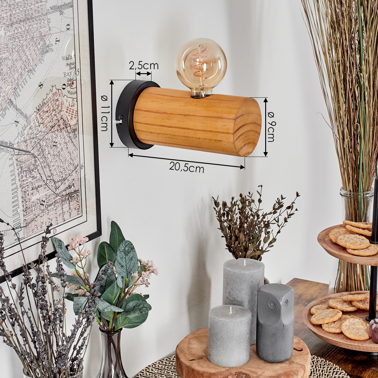 Eine Wandlampe aus Holz mit Glühbirne, Karte, Kerzen und Dekorationen auf einem Tisch, einschließlich Keksen und Pflanzen.