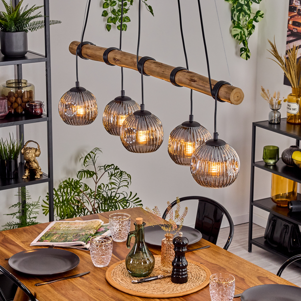 Ein Esszimmer mit Holztisch, Hängelampen und Dekorationsartikeln. Die Lampen sind rund mit gerippter Textur.