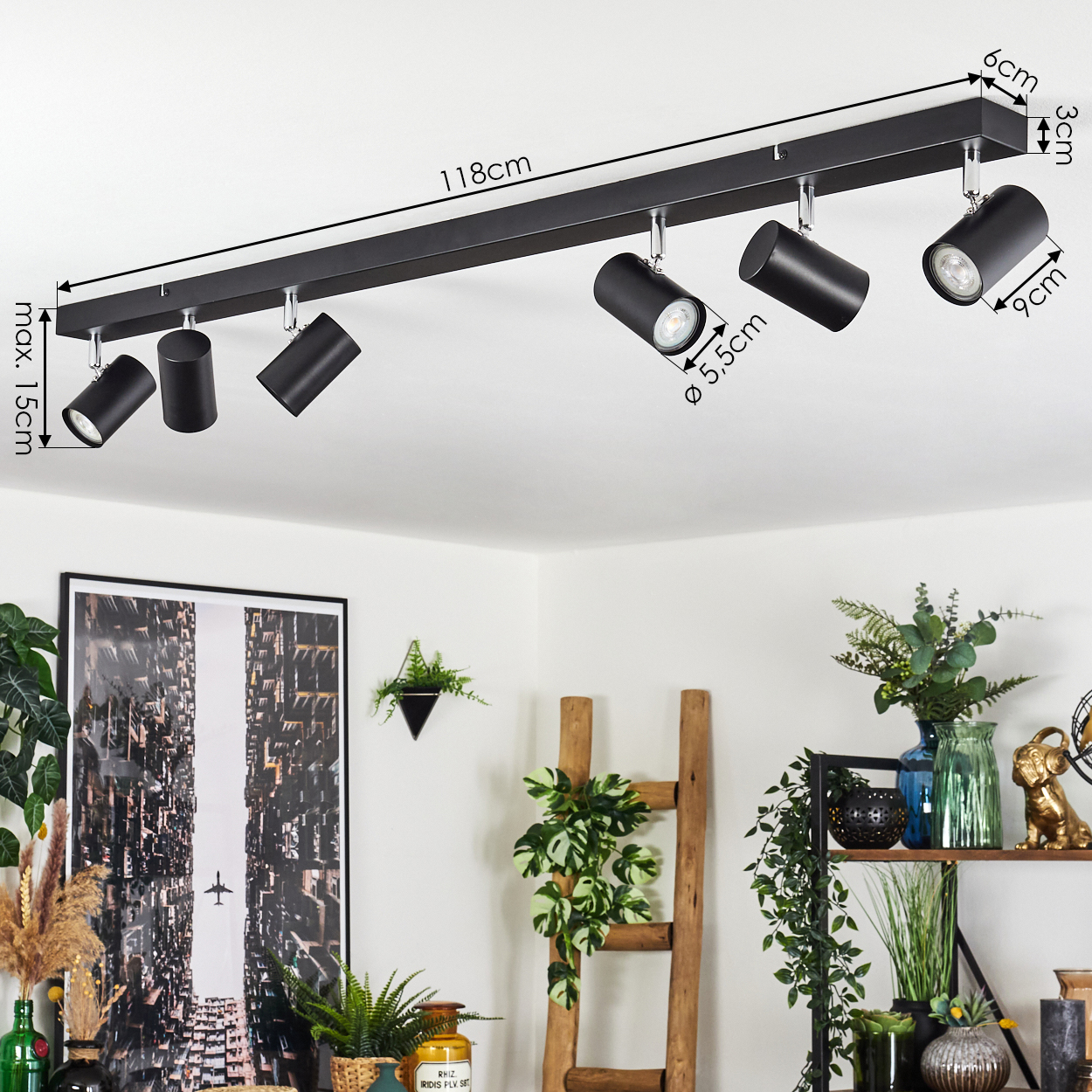 Schwarze Deckenstrahler. Ein Bild und Pflanzen sind im Hintergrund. Holzleiter und Regal mit Dekoration.