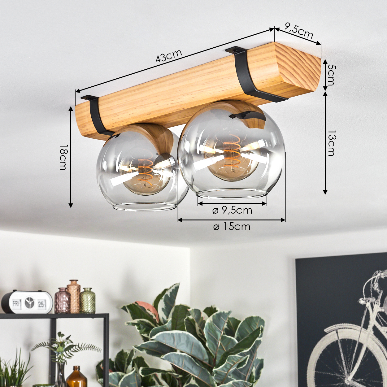 Holzdeckenlampe mit zwei Glaskugelschirmen. Abmessungen und Maße sind angegeben. Hintergrund: Pflanzen und Dekoration.